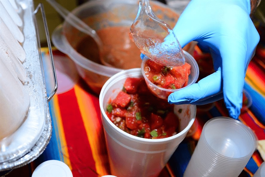 salsa being spooned in a small plastic container