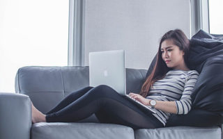 female-working-from-home-on-her-laptop-sitting-in-sofa