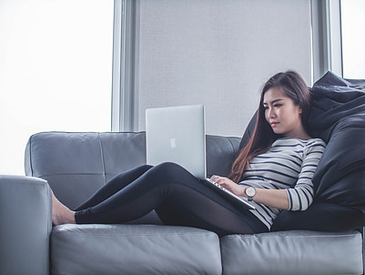 female-working-from-home-on-her-laptop-sitting-in-sofa