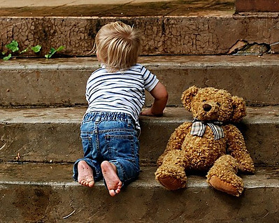 baby taking one step at a time with a brown teddy bear
