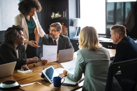 employees at an office desk talking