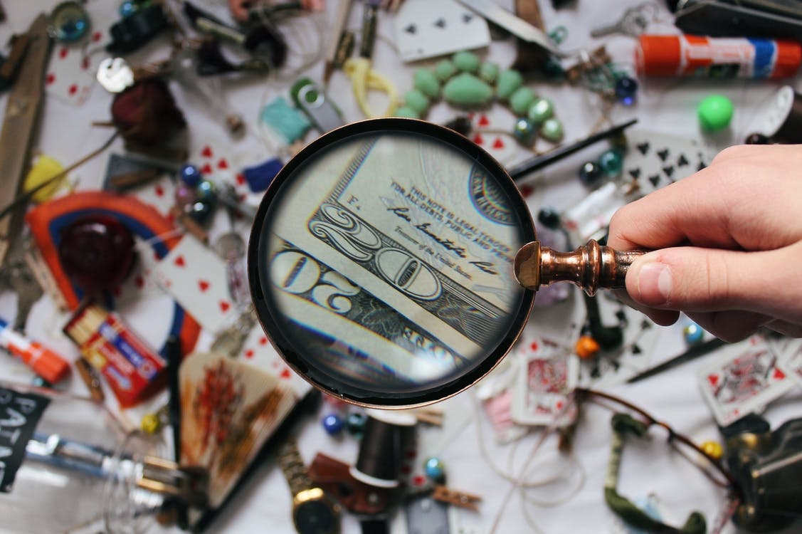 Close-up Photography of Magnifying Glass showing money essential parts of business