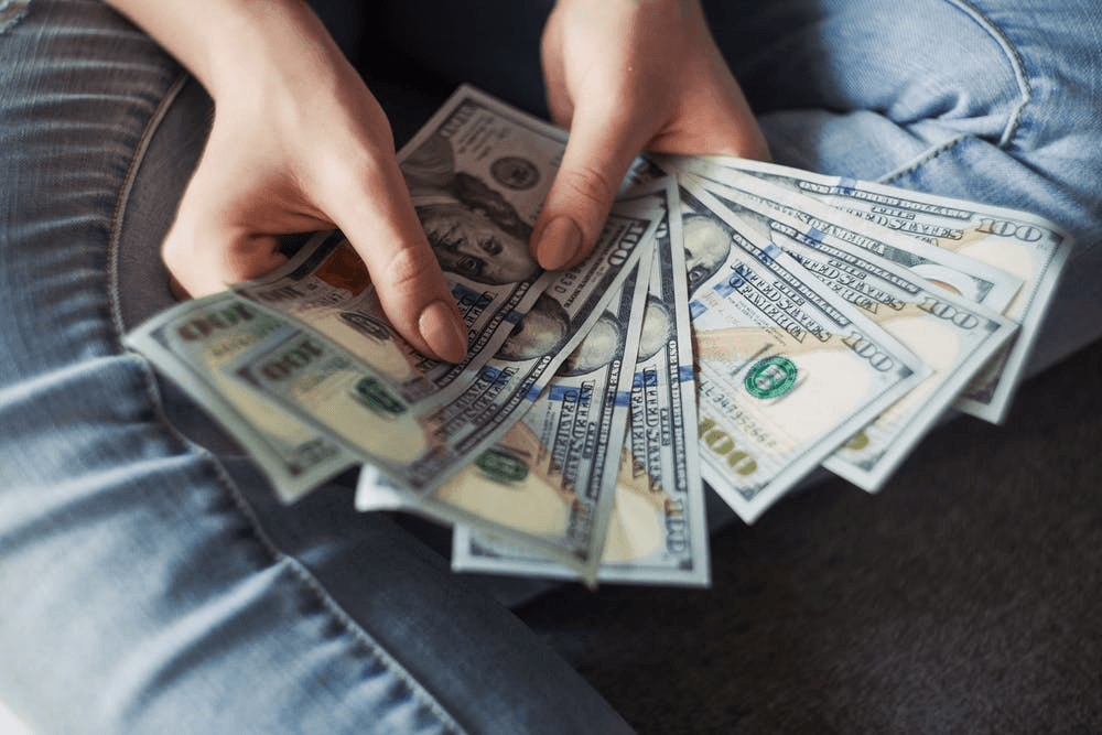 person-holding-100-us-dollar-banknotes- unexpected company expenses to take care of