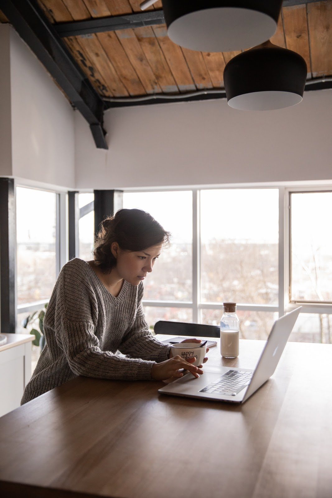 focused-young-woman-using-laptop-in-kitchen-during-breakfast improve your business website planning