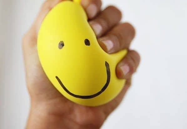 hand squeezing yellow stress ball work-related stress