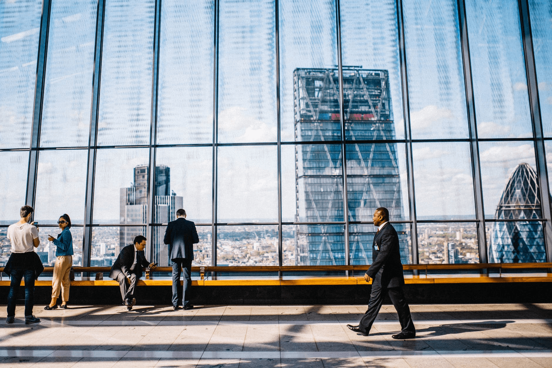 man-walking-on-sidewalk-near-people-standing-and-sitting-beside-curtain-wall-building warning signs