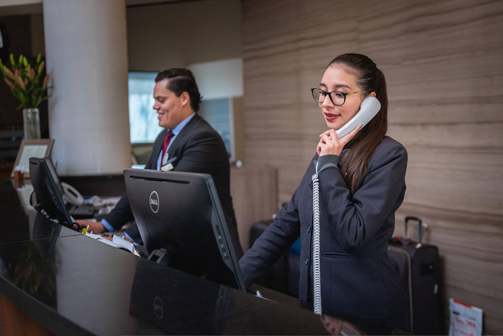 employee on the phone at reception desk good business impression