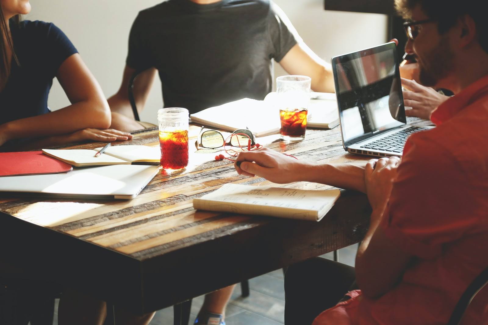 employees discussing essentials for business start up at a table with laptop